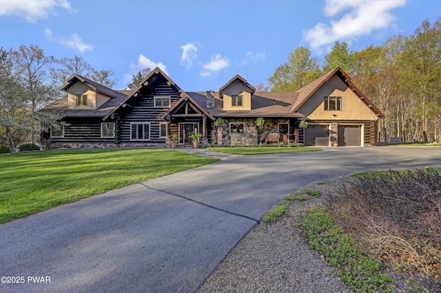 log-style house with aphalt driveway, stone siding, a front yard, log exterior, and an attached garage