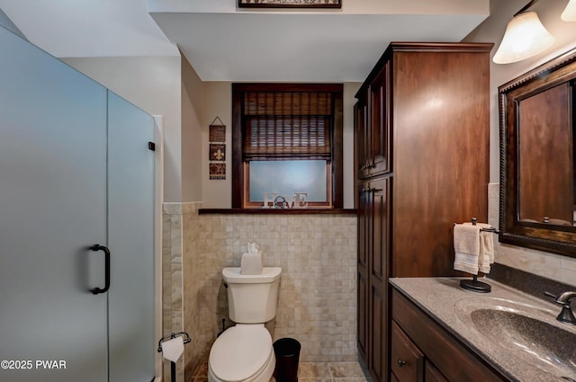 full bathroom with wainscoting, vanity, toilet, tile walls, and a shower stall