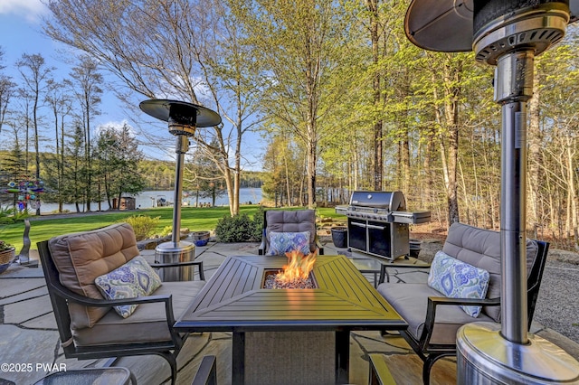 view of patio / terrace with a fire pit, a water view, and a grill