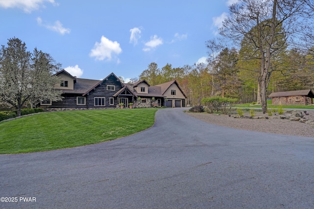 view of front of house featuring a garage, a front lawn, and aphalt driveway
