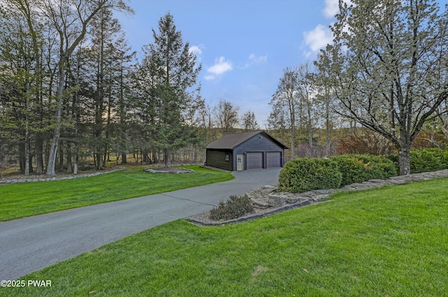 view of front of property with a detached garage, an outdoor structure, and a front yard