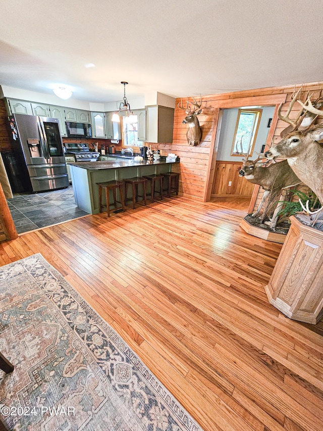 living room featuring wood walls, wood-type flooring, and a wealth of natural light