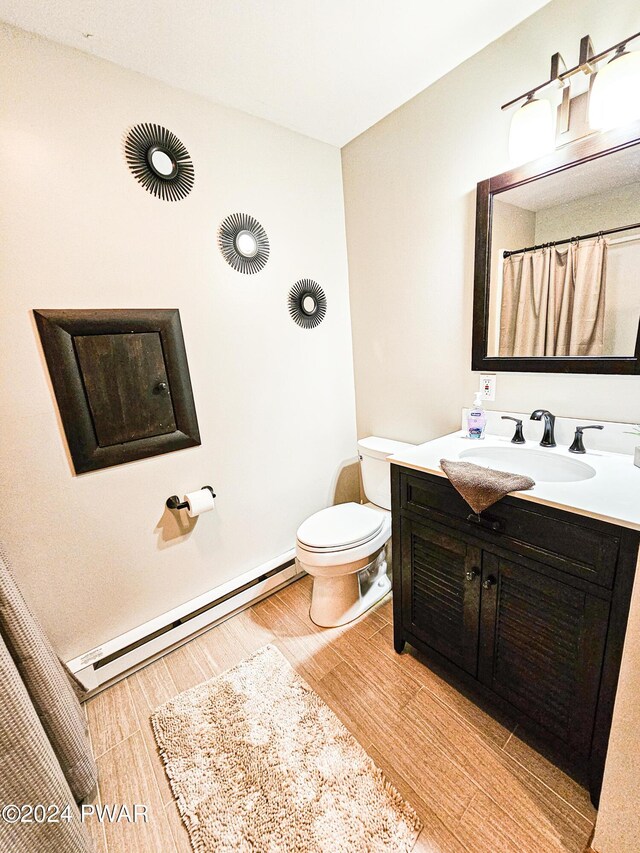 bathroom with vanity, toilet, and a baseboard heating unit