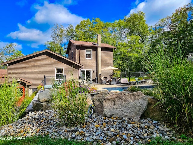 back of house with a patio area and a swimming pool