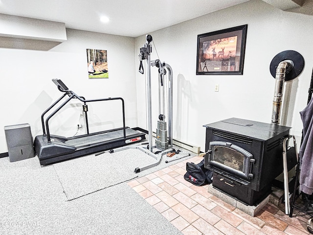 exercise room featuring a wood stove and baseboard heating