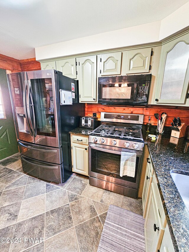 kitchen featuring stainless steel appliances and dark stone counters