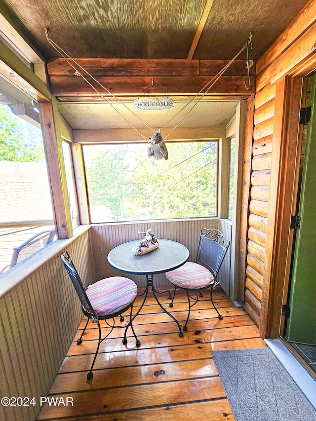 sunroom / solarium featuring breakfast area, a healthy amount of sunlight, and wooden ceiling