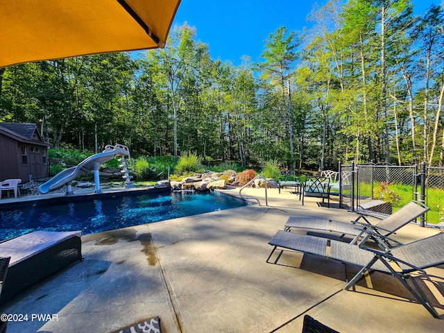 view of swimming pool with a patio and a water slide