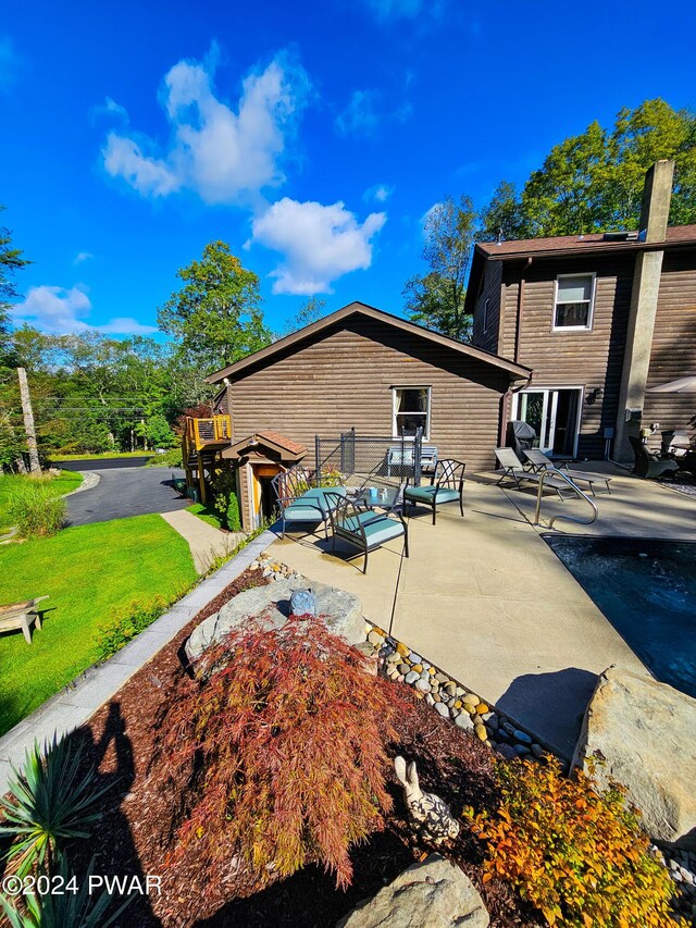 rear view of property with a yard, a patio area, and outdoor lounge area