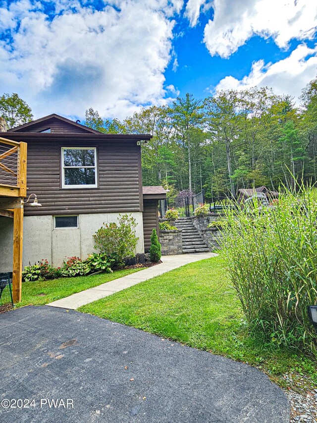 view of side of home with a yard