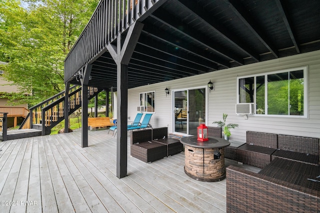 deck featuring cooling unit and an outdoor living space with a fire pit