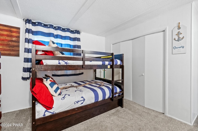 bedroom with carpet flooring, a textured ceiling, and a closet