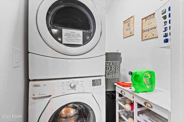 washroom with stacked washing maching and dryer