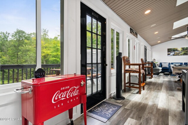 doorway featuring ceiling fan, hardwood / wood-style floors, wood ceiling, and lofted ceiling