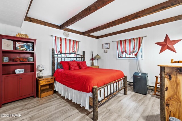 bedroom with beamed ceiling, light hardwood / wood-style flooring, and a baseboard heating unit