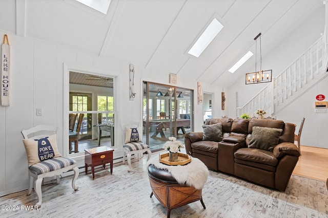 living room featuring light wood-type flooring, high vaulted ceiling, and an inviting chandelier