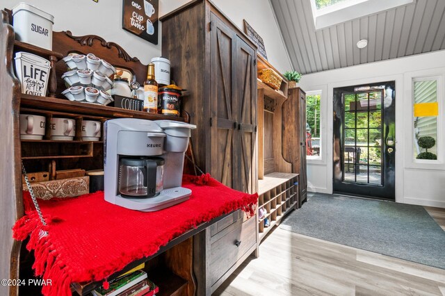 mudroom featuring light hardwood / wood-style floors and lofted ceiling with skylight