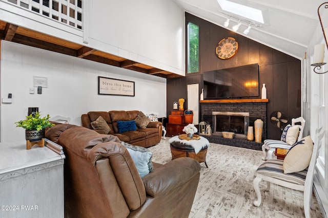 living room featuring wood walls, a fireplace, and vaulted ceiling