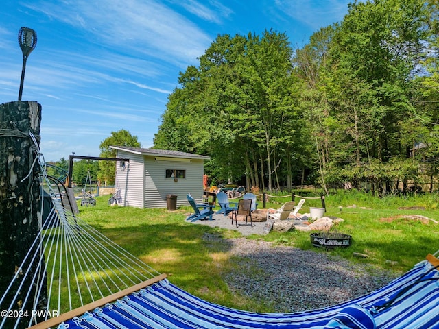 view of yard featuring a fire pit and an outdoor structure