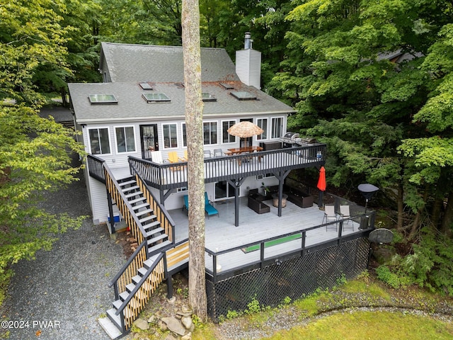 rear view of house with an outdoor living space and a wooden deck