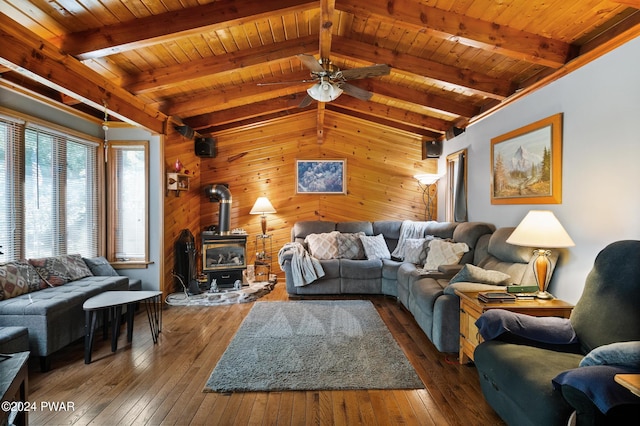 living room featuring ceiling fan, a wood stove, wooden walls, and wooden ceiling