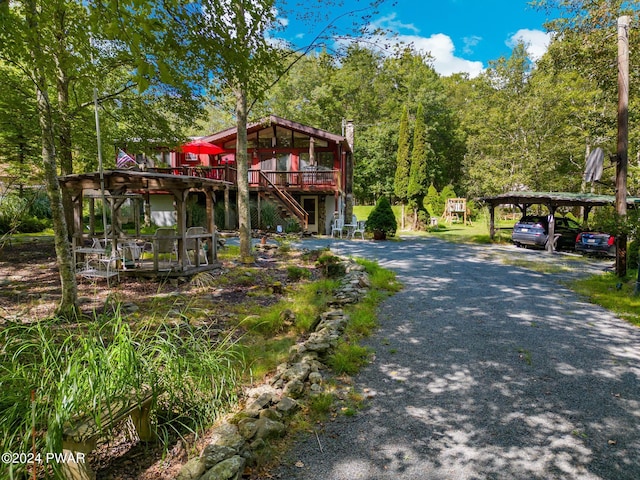 exterior space with a deck, stairway, a chimney, and a wooded view