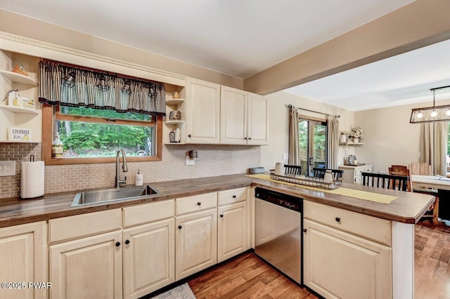 kitchen with stainless steel dishwasher, kitchen peninsula, sink, and butcher block countertops