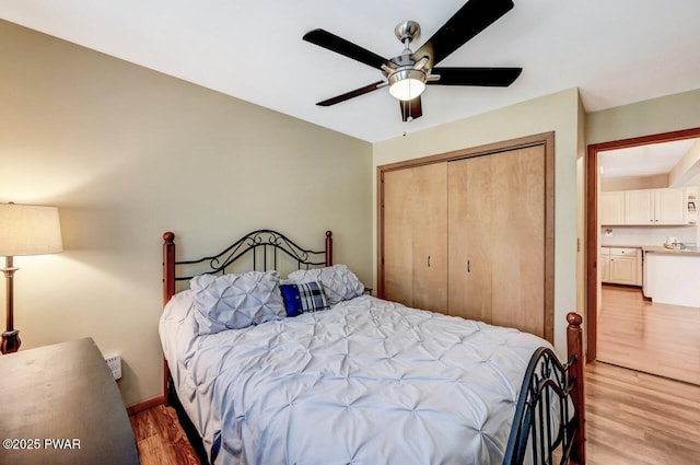 bedroom with wood-type flooring, a closet, and ceiling fan