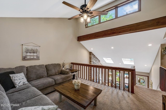 living room with ceiling fan, a healthy amount of sunlight, a skylight, and high vaulted ceiling