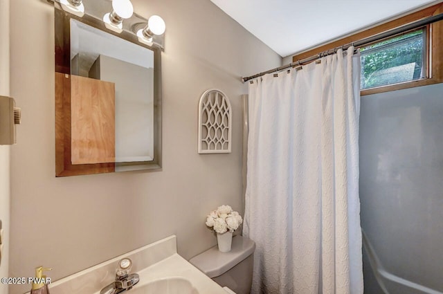 bathroom featuring sink, toilet, and a shower with shower curtain