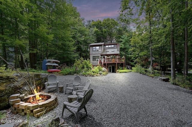 exterior space with a wooden deck, a patio area, and a fire pit