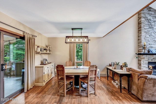 dining space featuring a fireplace and light hardwood / wood-style floors