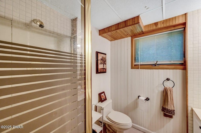 bathroom with wooden walls and toilet