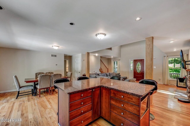 kitchen with light hardwood / wood-style floors and dark stone countertops