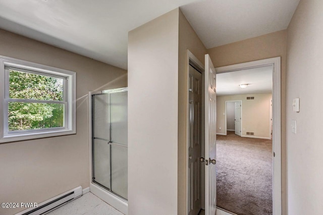 bathroom featuring a shower with shower door and a baseboard heating unit