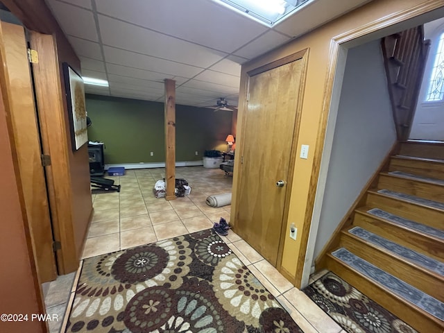 hall with a drop ceiling and light tile patterned flooring