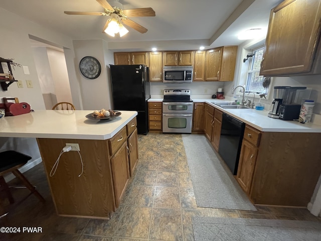 kitchen with black appliances, ceiling fan, sink, and a breakfast bar area