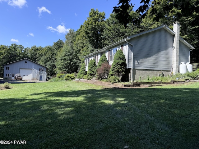 view of yard with a garage and an outbuilding