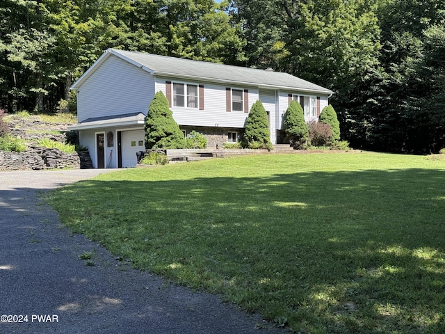 split foyer home with driveway, an attached garage, and a front yard