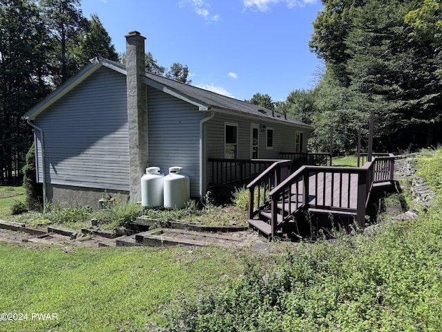 back of property featuring a yard and a deck