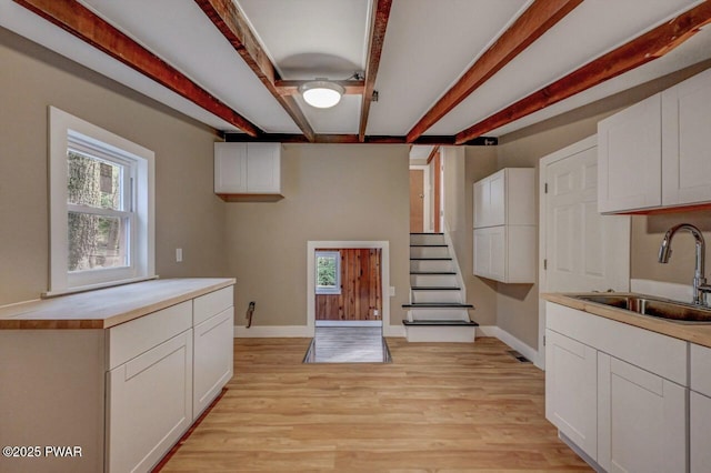 110 Maple Dr, Greentown, PA 18426 - kitchen featuring beam ceiling, white cabinets, light wood finished floors, and a sink