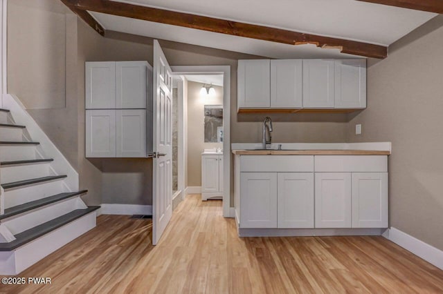 110 Maple Dr, Greentown, PA 18426 - kitchen featuring a sink, beam ceiling, light wood-type flooring, baseboards, and white cabinets