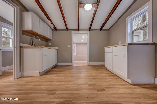 110 Maple Dr, Greentown, PA 18426 - kitchen featuring beam ceiling, a healthy amount of sunlight, white cabinetry, and baseboards