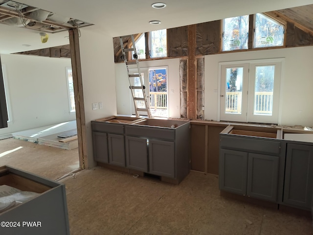 kitchen featuring gray cabinets, plenty of natural light, and lofted ceiling