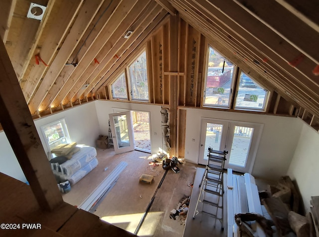 unfurnished living room featuring french doors and vaulted ceiling