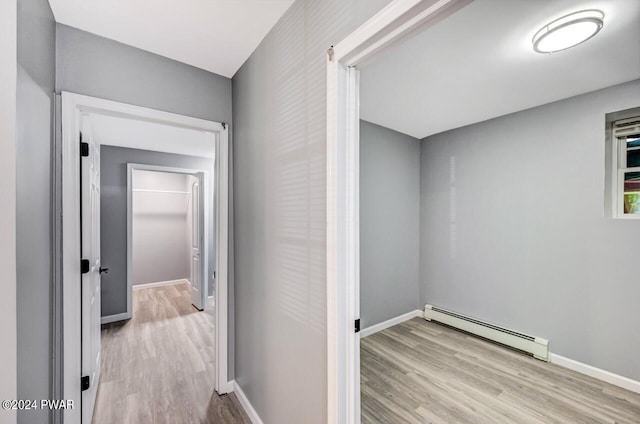 corridor featuring baseboard heating and light hardwood / wood-style flooring
