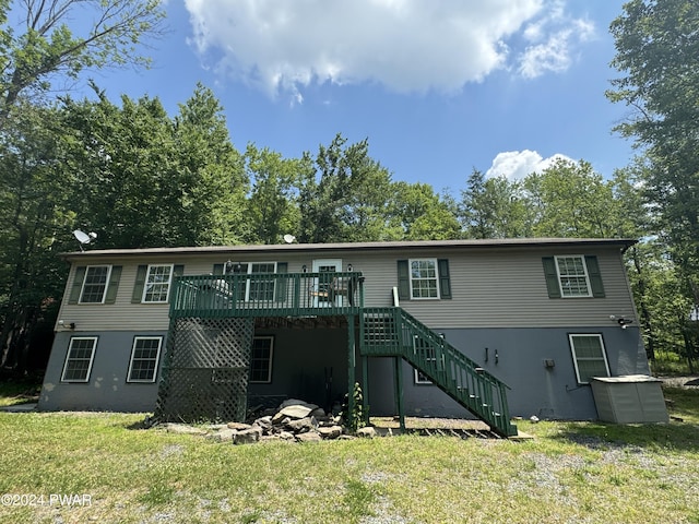 back of house featuring a lawn and a wooden deck