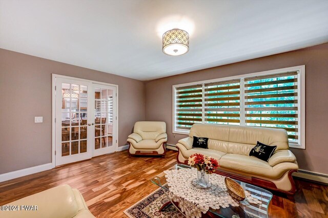 living room featuring french doors, a baseboard heating unit, and hardwood / wood-style floors