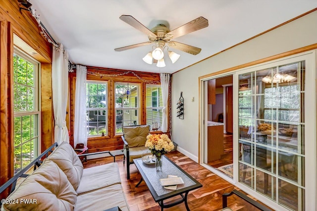 sunroom / solarium with ceiling fan with notable chandelier