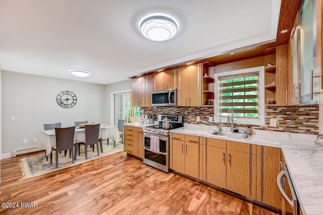 kitchen featuring decorative backsplash, appliances with stainless steel finishes, a baseboard heating unit, and sink